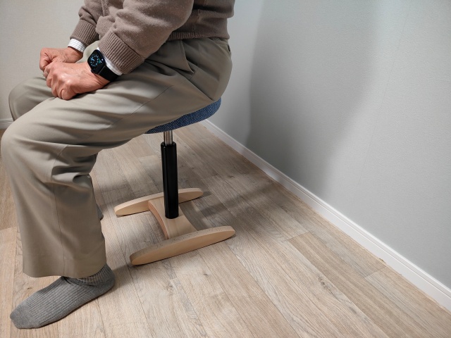 バランスラボの腰痛対策椅子・バランスシナジーに座る中年男性