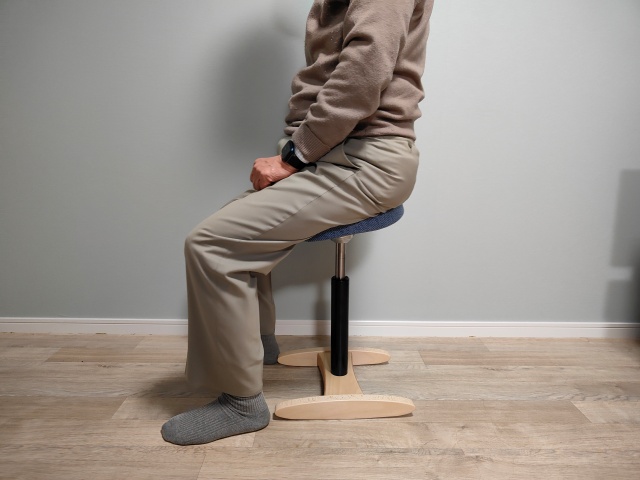 バランスラボの腰痛対策椅子・バランスシナジーに座る中年男性